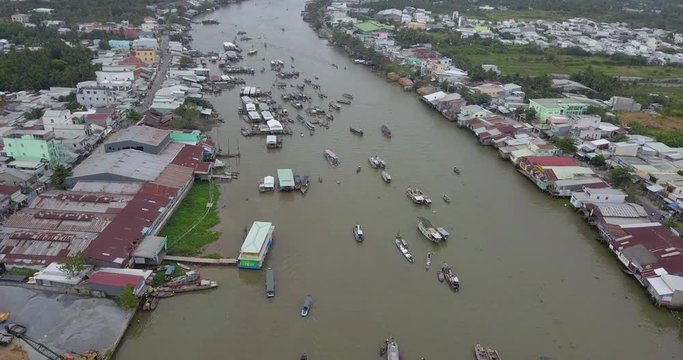 Aerial view, top view of Cai Rang floating market. Tourists and people buy and sell food, vegetable, fruits on boat, ship on river market. Traditional popular method of buying and selling on river