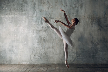 Fototapeta na wymiar Ballerina female. Young beautiful woman ballet dancer, dressed in professional outfit, pointe shoes and white tutu.