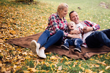 Fototapeta premium Little cute son playing with parents in forest