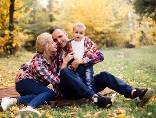 Fototapeta premium Little cute son playing with parents in forest