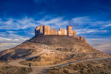 Obraz premium Aerial view of the ruined medieval abandoned Montearagon castle, namesake of the famous kingdom on a bare mountain top near Huesca, Aragon province Spain with blue sky