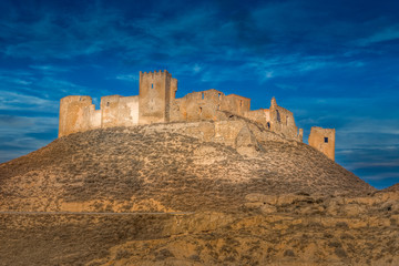 Fototapeta na wymiar Aerial view of the ruined medieval abandoned Montearagon castle, namesake of the famous kingdom on a bare mountain top near Huesca, Aragon province Spain with blue sky