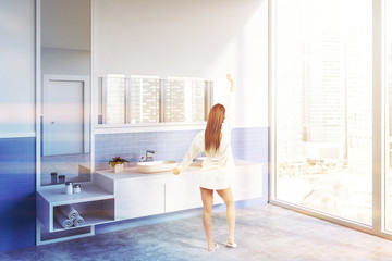 Fototapeta na wymiar Side view of white bathroom with double sink woman