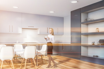 Kitchen corner with cupboard and table, woman