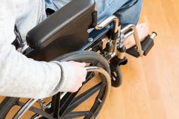 Fototapeta premium Szczegółowo niepełnosprawny mężczyzna ręka trzyma koło wózka inwalidzkiego.