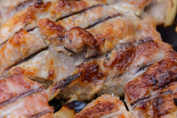 Grilled kebab cooking on metal grille (grill). Roasted meat cooked at barbecue with smoke. Close up BBQ fresh pork meat chop slices. Traditional eastern dish, shish kebab.