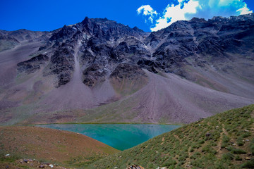 Turquoise water of the Chandrataal Lake reflecting the mountains 
