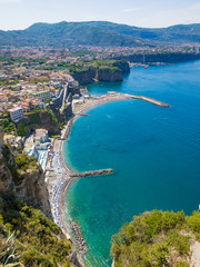 Aerial view of cliff coastline Sorrento and Gulf of Naples in Italy. Sunny summer day with blue sky, clear sea and green mountains of Sorrento Peninsula.