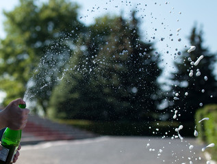 champagne splatters coming out of the bottle.