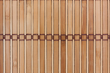 Beige bamboo mat with dark threads. Texture for background and design.