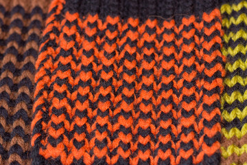 Knitting. Background knitted texture. Bright knitting needles. Orange and black wool yarn for knitting.