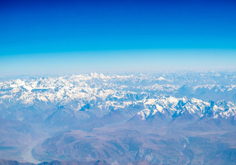 Obraz premium Mountains earth from aircraft under blue sky