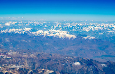 Fototapeta premium Mountains earth from aircraft under blue sky