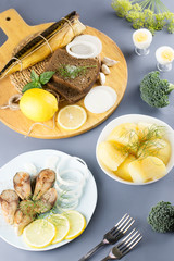 Sliced salted fish with lemon and seasoning, boiled potatoes on a table