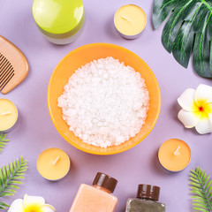 Obraz na płótnie Canvas Spa and body care products flat lay. Body scrub, bath salt, moisturizing lotion, candles and leaves on wooden background