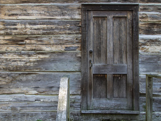 Closed Front Door. Weathered wood home with closed front door and old lock.