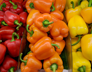 Red orange and yellow sweet peppers on marketplace