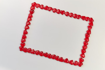 Obraz premium frame lined from small glass hearts on a white background. Valentine's Day. Love symbol
