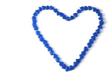 Heart-shaped laid out of small glass navy blue hearts on white background. Top view. Valentine's Day. Symbol of gay love. Copy space.