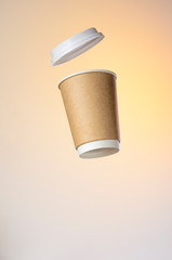 Paper cup of coffee with a plastic cap levitates in the air. Paper Cup Layout For Advertising. Empty Place for Logo Placement