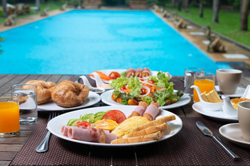 Food series: American breakfast set on wooden table by the pool