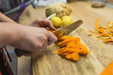 Young woman cutting vegetables in kitchen