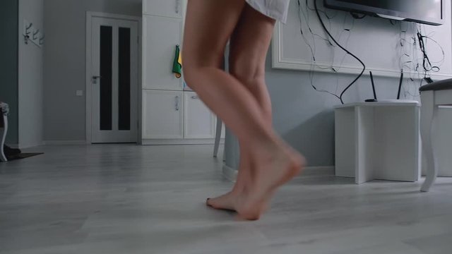 Morning get up from the bed. Female feet goes on floor into bathroom.