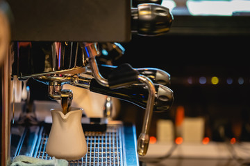 Close-up of espresso shot pouring from coffee machine in coffee shop