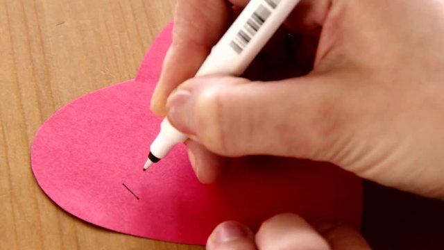 I love you written on a red paper heart