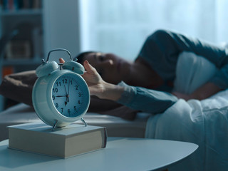 Woman waking up in the morning and alarm clock