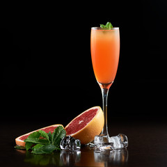 Tall narrow crystal cocktail glass with cold summer refreshing orange juicy drink, slices of...