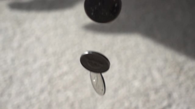 Slow Motion Canadian Coins Falling On Carpet With Shadows In Distance