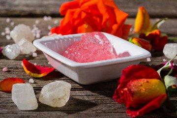 anti aging revitalize gel, salt crystals and roses on old wood table background
