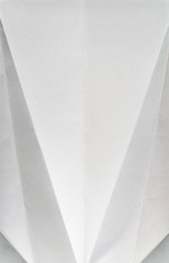Folded white colour paper. Pastel tones. Hard natural light. Folds and wrinkles on paper. Geometric shapes