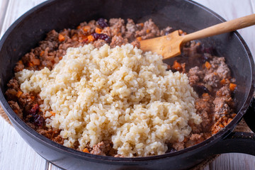 Pilaf of bulgur with meat on wooden table