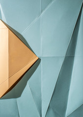 Folded pantone color paper and blue color. Pastel tones. Hard natural light. Folds and wrinkles on paper. Geometric shapes