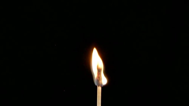 Detail of burning match on a black background