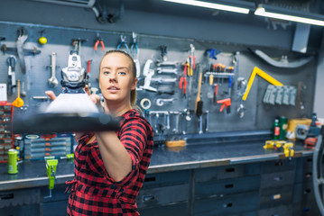 Photo of Mechanic woman repairing a ski in workshop
