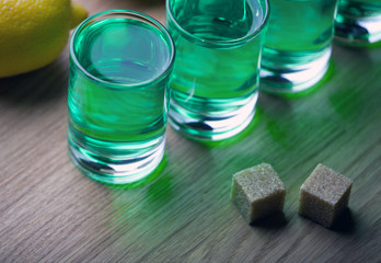 absinthe shot glass sugar lemon wooden table 
