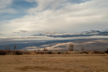 Fototapeta premium cloud covered mountain range in desert valley landscape