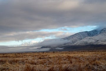 Fototapeta premium winter valley clouds hang around mountain range snowy peaks morning