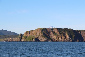 Fototapeta na wymiar View of coastline of the Kamchatka Peninsula, Russia. In the background is visible Vilyuchinsky volcano (also called Vilyuchik).