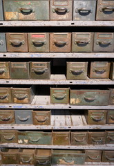 Old rusty shelf with many drawers and boxes for in a disused workshop