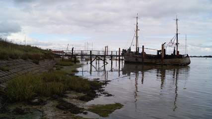 Fototapeta na wymiar Old Wooden Yachts on Mud Flats in Essex