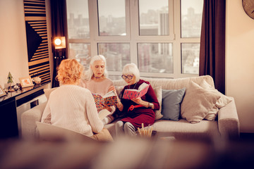 Obraz premium Nice pleasant aged women exchanging their books