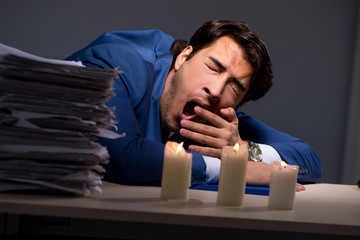 Obraz premium Businessman working late in office with candle light