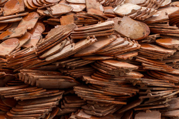 Stack of roof tiles traditional clay for temple construction process in vintage style which textured of surface natural color background.