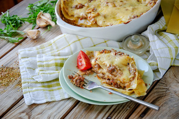 Traditional lasagna made with minced beef bolognese sauce and bechamel sauce with pepper and herbs