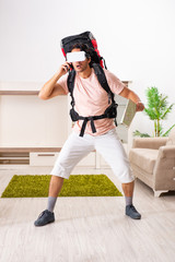 Young male tourist with virtual glasses preparing for trip 