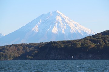 Koryaksky volcano rises above the coastline of the Kamchatka Peninsula. Koryaksky or Koryakskaya Sopka is an active volcano on the Kamchatka Peninsula in the Russian Far East.